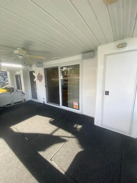 Slide: The Image of 2000 Sumerset 18x85 Houseboat interior with carpeted floor and sliding glass doors. - 28