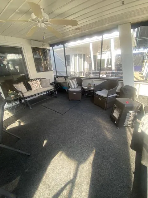 Slide: The Image of Cozy interior of 2000 Sumerset 18x85 houseboat with seating and ceiling fan. - 3