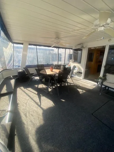 Slide: The Image of Spacious interior of 2000 Sumerset 18x85 houseboat with dining area and ceiling fans. - 32