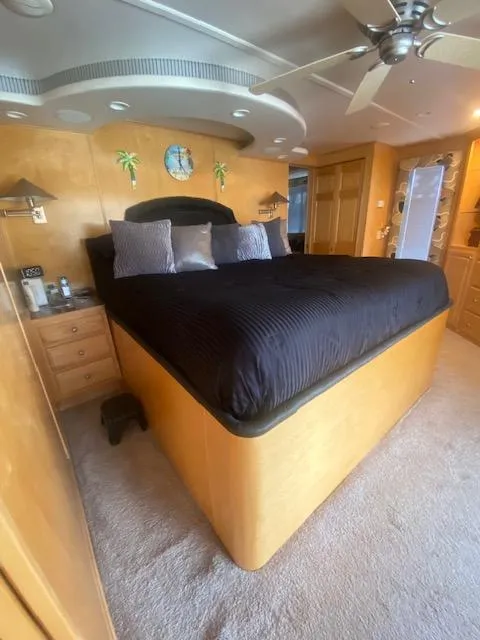 Slide: The Image of Luxurious bedroom in 2000 Sumerset 18x85 houseboat with modern decor and ceiling fan. - 9