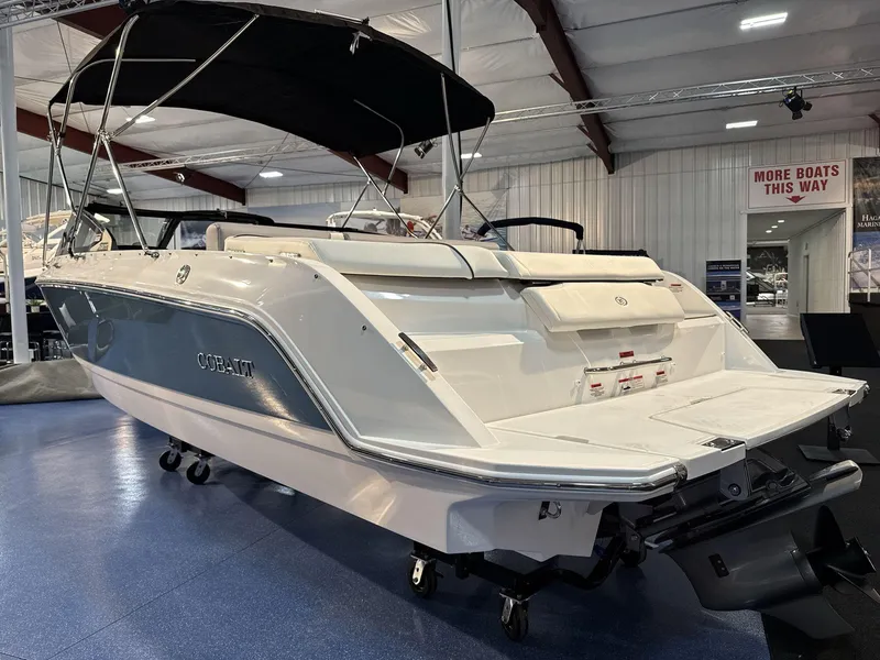Slide: The Image of 2025 Cobalt CS22 boat displayed indoors with black canopy. - 6