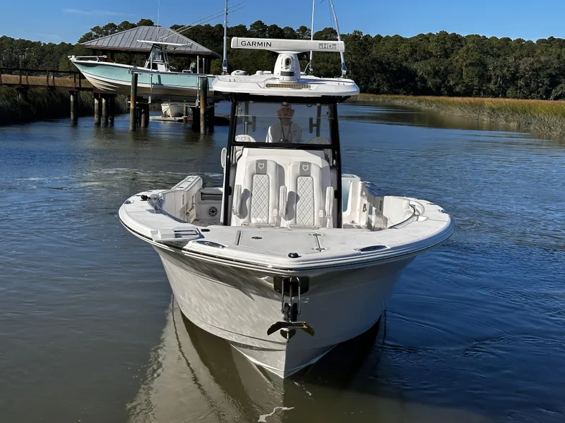 Slide: The Image of 2025 Sea Fox 328 Commander boat on calm water near dock. - 2