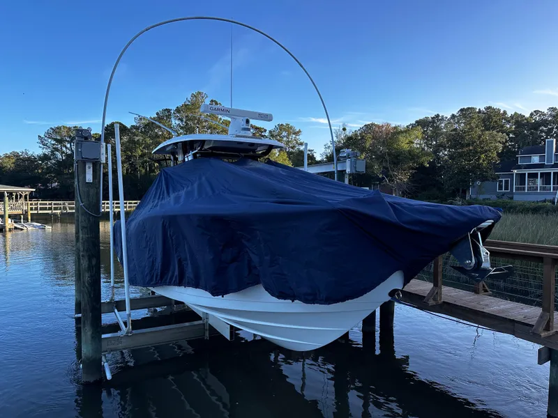 Slide: The Image of 2025 Sea Fox 328 Commander boat covered and docked by the water. - 39