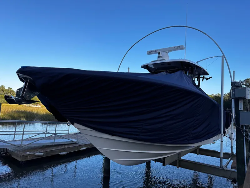 Slide: The Image of 2025 Sea Fox 328 Commander boat covered and docked on a lift. - 40