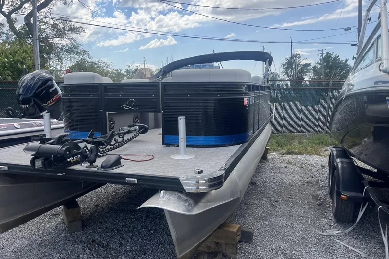 Slide: The Image of 2023 Qwest Lanai 818 pontoon boat on gravel lot, under clear sky. - 10
