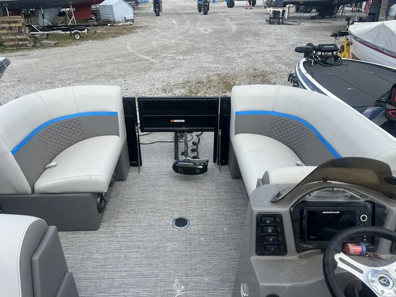 Slide: The Image of 2023 Qwest Lanai 818 pontoon boat interior with seating and steering console. - 2