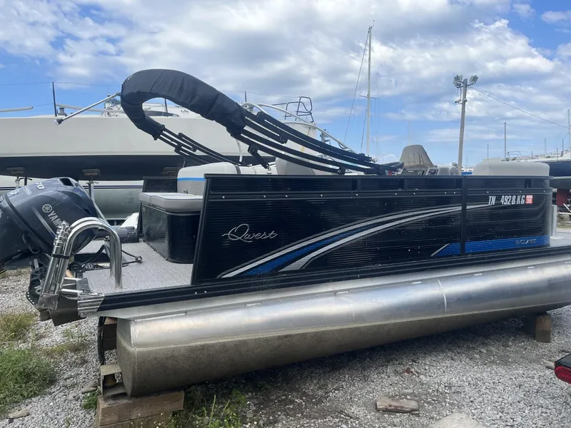 Slide: The Image of 2023 Qwest Lanai 818 pontoon boat on gravel, Yamaha motor, blue sky background. - 5