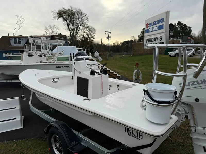 Slide: The Image of 2025 Delta Boatworks Delta 18 on trailer at dealership, featuring Suzuki Marine engine. - 5