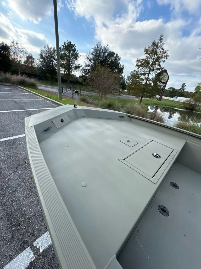 Slide: The Image of 2025 Tracker Grizzly 1860 CC boat parked near a scenic lake. - 4