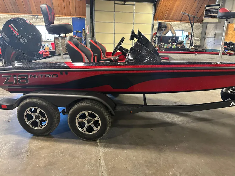 Slide: The Image of 2025 Nitro Z18 Pro boat in a garage, featuring red and black design with dual axles. - 2