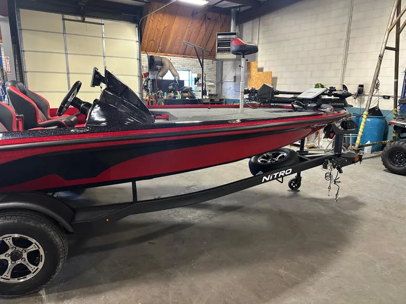 Slide: The Image of 2025 Nitro Z18 Pro fishing boat in a garage, featuring a sleek red and black design. - 5
