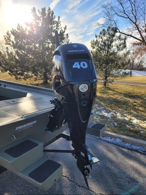 Slide: The Image of 2025 Tracker Grizzly 1654 T Sportsman boat with Mercury 40 outboard motor in scenic outdoor setting. - 2