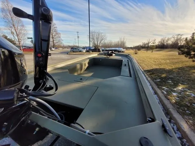 Slide: The Image of 2025 Tracker Grizzly 1654 T Sportsman boat in a parking lot under a blue sky. - 3