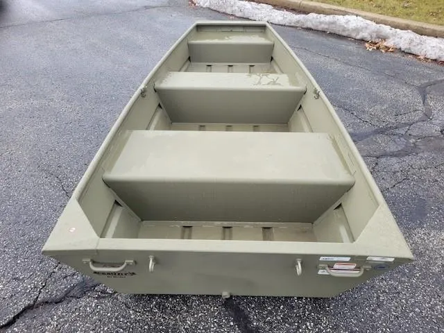 Slide: The Image of 2025 Tracker Grizzly 1036 Utility boat on pavement, showcasing interior seating and design. - 2