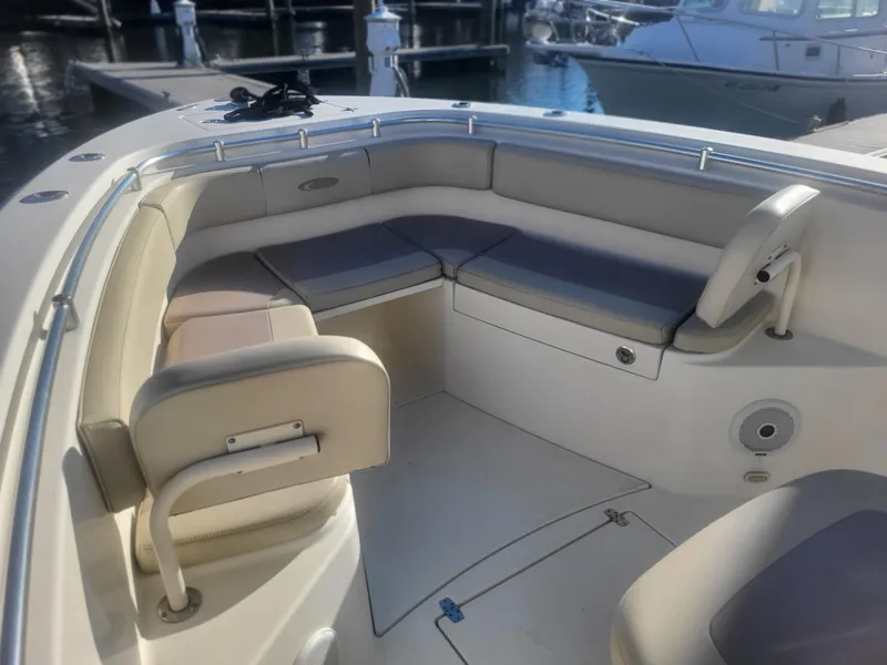 Slide: The Image of 2016 Cobia 277 Center Console boat interior with cushioned seating at dock. - 17