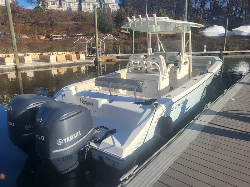 Slide: The Image of 2016 Cobia 277 Center Console boat docked with twin Yamaha engines. - 2
