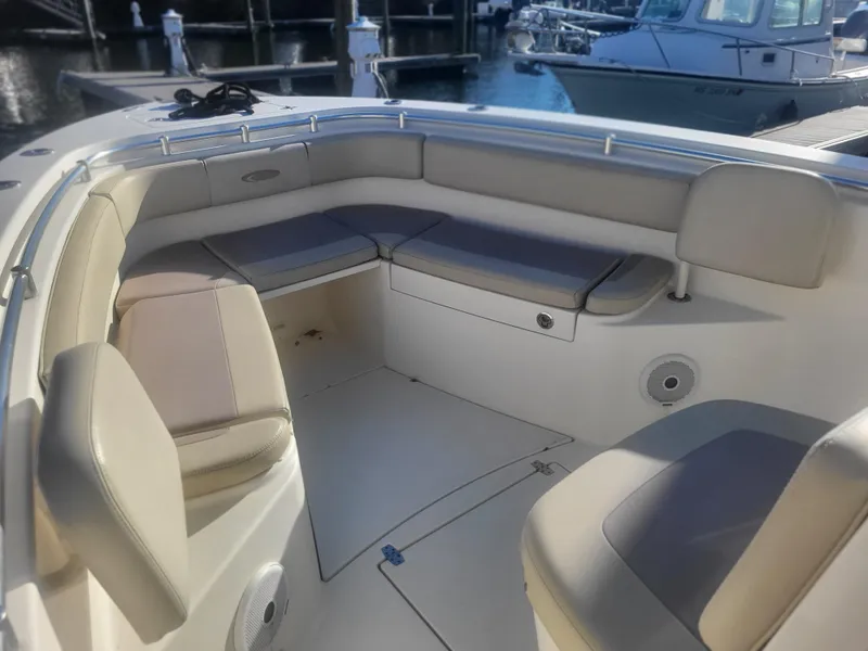 Slide: The Image of 2016 Cobia 277 Center Console boat interior with cushioned seating at marina. - 20
