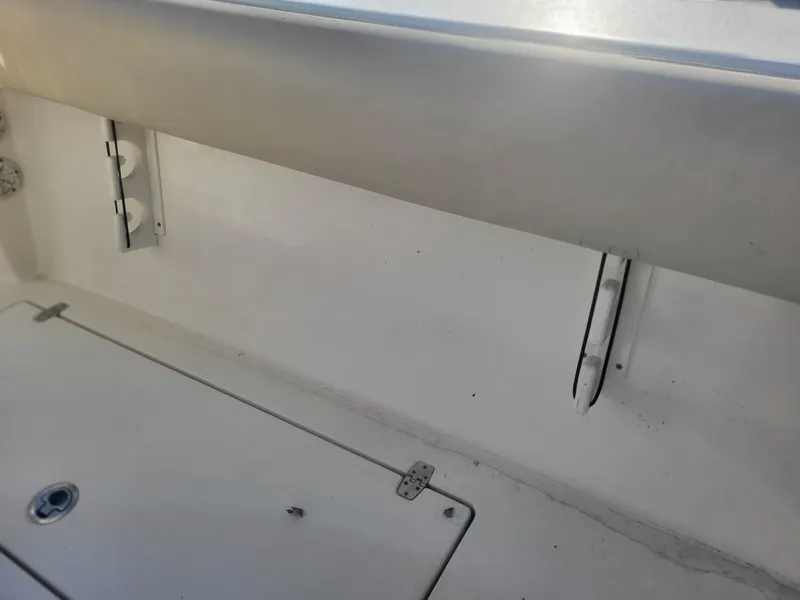 Slide: The Image of 2016 Cobia 277 Center Console interior detail, showing storage compartment and hinges. - 22