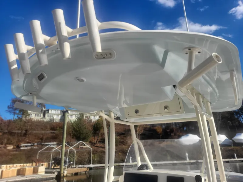 Slide: The Image of 2016 Cobia 277 Center Console boat with rod holders and electronics, under a clear blue sky. - 39