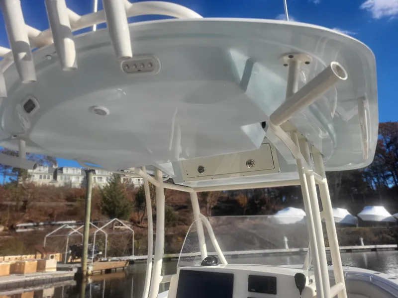 Slide: The Image of 2016 Cobia 277 Center Console boat with T-top and rod holders at a marina. - 40