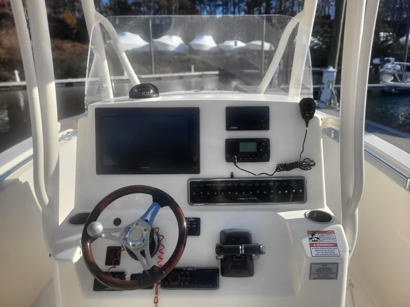 Slide: The Image of 2016 Cobia 277 Center Console dashboard with steering wheel and electronic controls. - 48