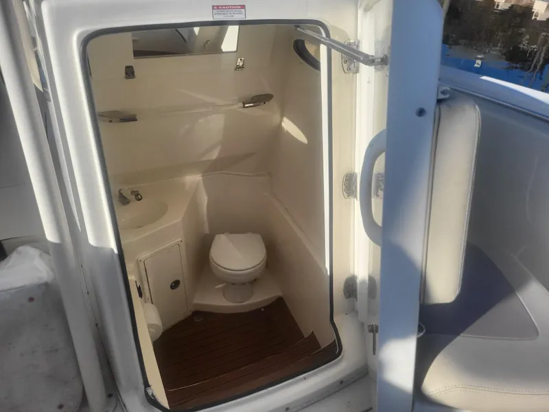 Slide: The Image of 2016 Cobia 277 Center Console boat interior bathroom with sink and toilet. - 7