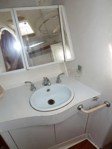 Slide: The Image of Bathroom sink area in a 1986 Wauquiez Centurion 47 yacht, featuring a mirror and faucet. - 10