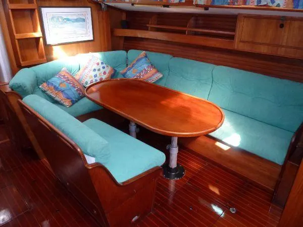 Slide: The Image of Interior of 1986 Wauquiez Centurion 47 yacht with teal seating and wooden table. - 11
