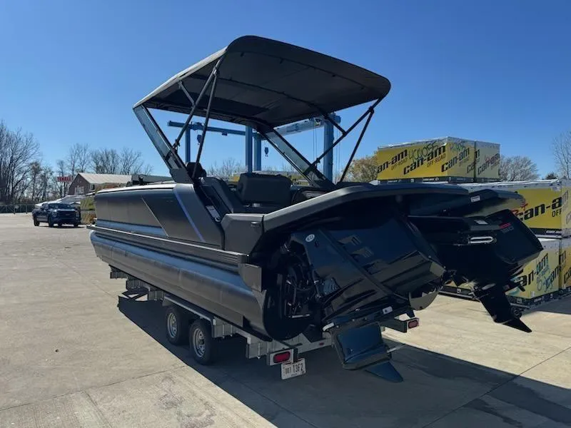 Slide: The Image of 2025 Manitou Navigator boat on trailer, parked outdoors under clear blue sky. - 3