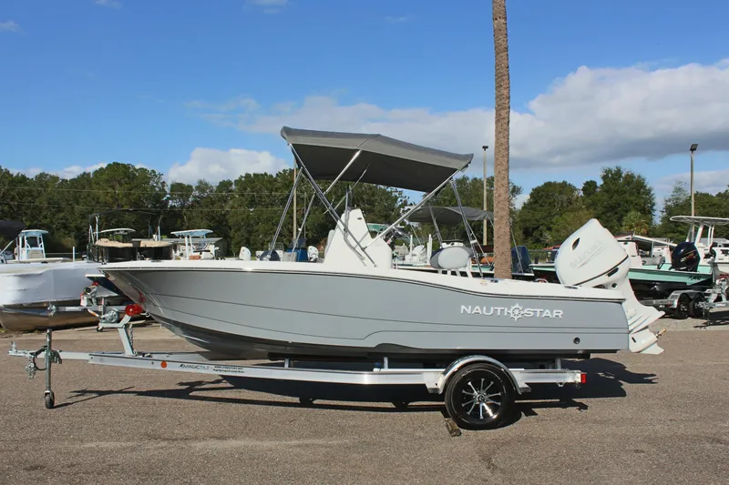 The Image of 2025 NauticStar 191 Hybrid boat on trailer, parked outdoors under clear sky. - 0
