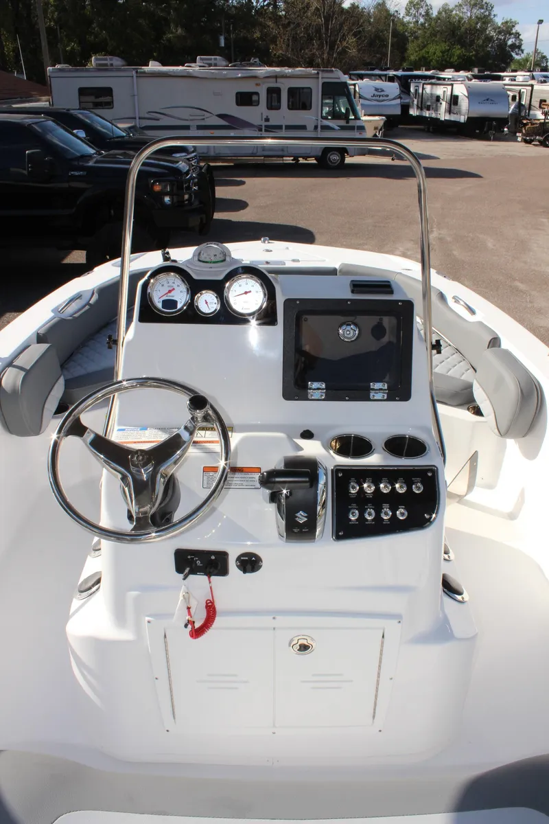 Slide: The Image of 2025 NauticStar 191 Hybrid boat dashboard with steering wheel and control panel. - 16