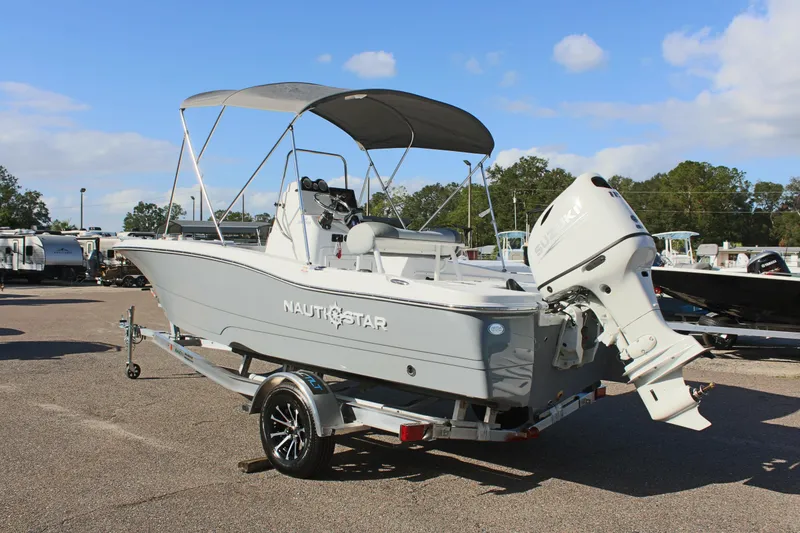 Slide: The Image of 2025 NauticStar 191 Hybrid boat with canopy on trailer in parking lot. - 8
