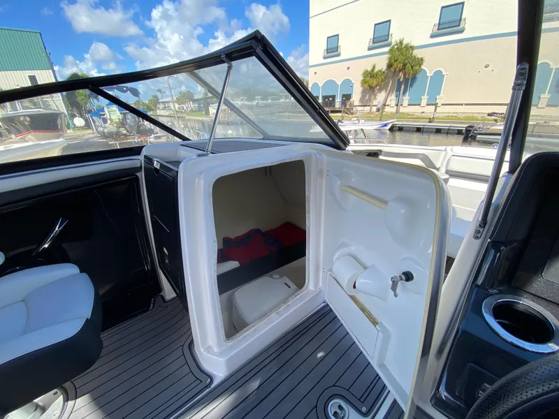 Slide: The Image of 2018 Yamaha Boats 242 Limited S interior cabin with open storage compartment. - 11
