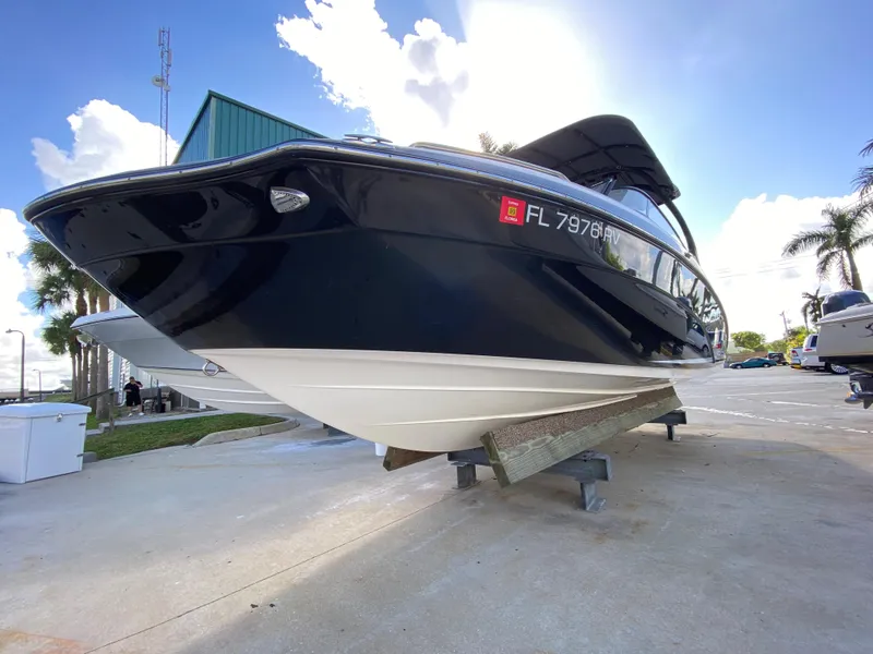 Slide: The Image of 2018 Yamaha Boats 242 Limited S on display, sleek black hull, sunny day. - 2