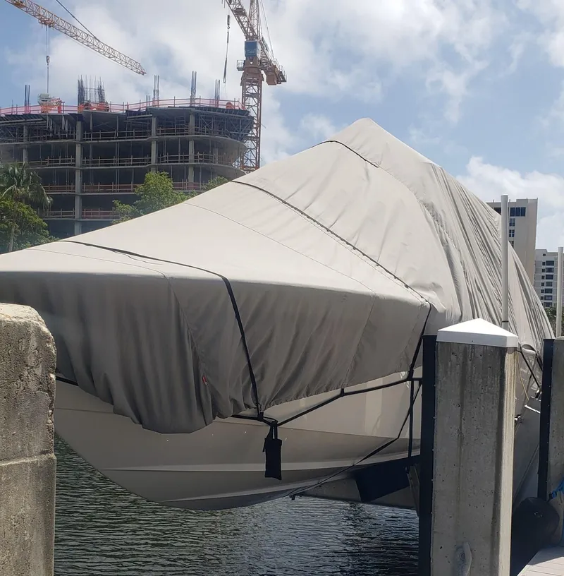 Slide: The Image of 2017 Invincible 33 Open Fisherman boat covered at dock, construction site in background. - 26