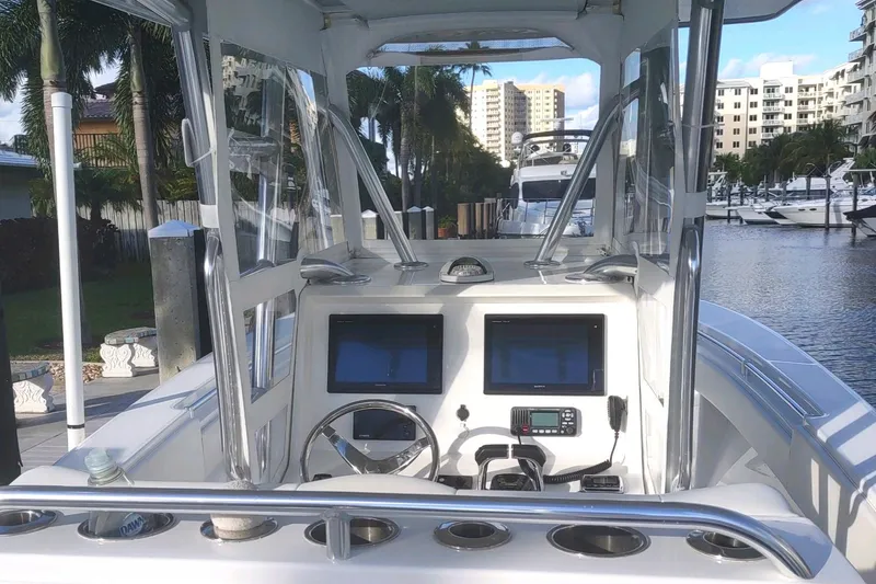 Slide: The Image of 2017 Invincible 33 Open Fisherman boat dashboard with dual screens, docked in a marina. - 6