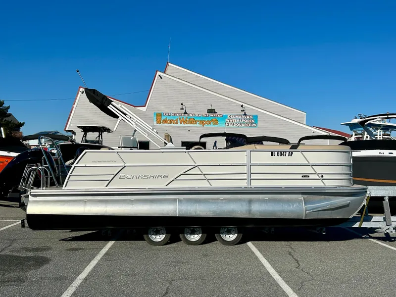 The Image of 2024 Berkshire 22CL2 CTS pontoon boat parked at a marina under clear blue skies. - 0