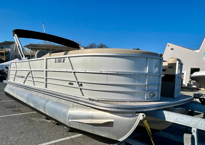 Slide: The Image of 2024 Berkshire 22CL2 CTS pontoon boat parked on trailer under clear blue sky. - 1