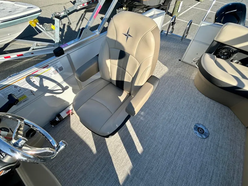 Slide: The Image of 2024 Berkshire 22CL2 CTS boat interior with beige captain's chair and steering wheel. - 10