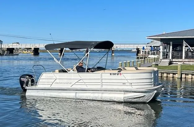 Slide: The Image of 2024 Berkshire 22CL2 CTS pontoon boat cruising on a sunny day near a dock. - 16