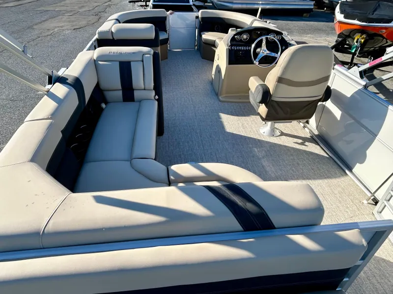 Slide: The Image of 2024 Berkshire 22CL2 CTS pontoon boat interior with beige seating and steering console. - 5