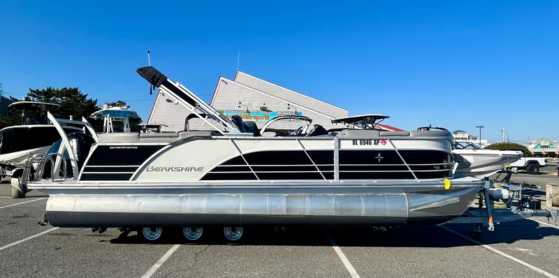 The Image of 2024 Berkshire 23RFX STS 3.0 pontoon boat parked outdoors under clear blue sky. - 0
