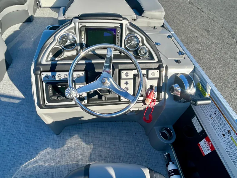 Slide: The Image of 2024 Berkshire 23RFX STS 3.0 boat dashboard with steering wheel and controls. - 12
