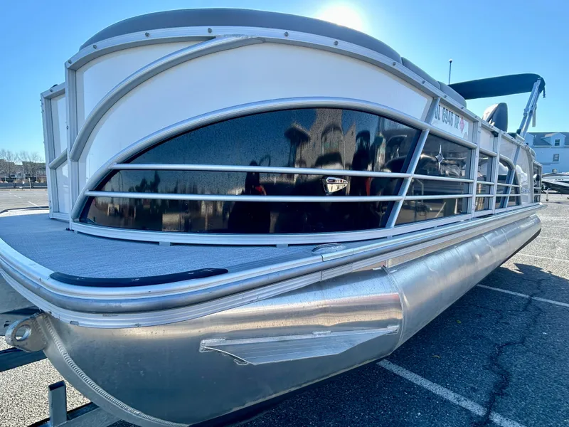 Slide: The Image of 2024 Berkshire 23RFX STS 3.0 pontoon boat in a parking lot, side view. - 3