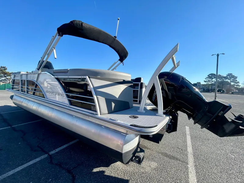 Slide: The Image of 2024 Berkshire 23RFX STS 3.0 pontoon boat with outboard motor in a parking lot. - 4