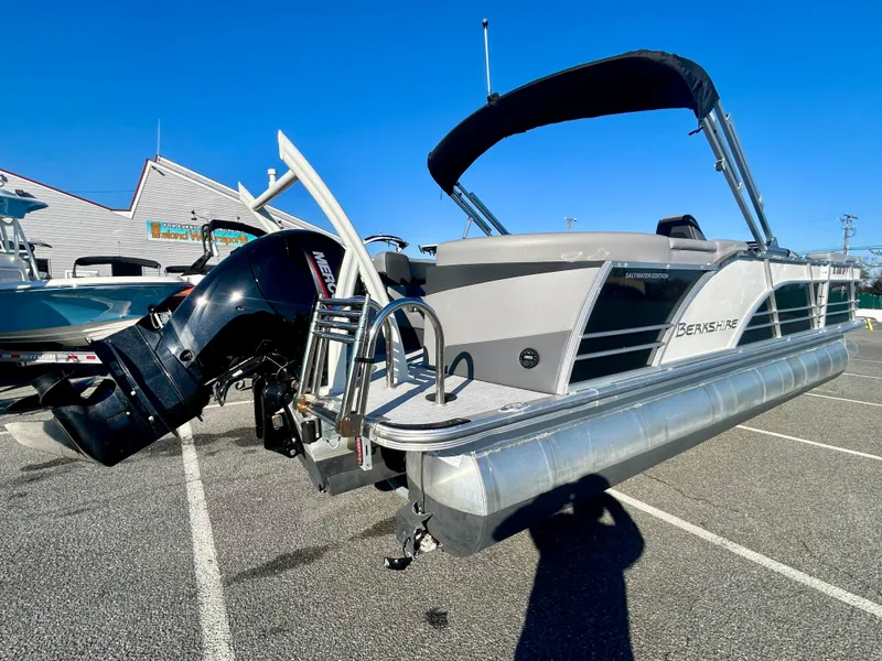 Slide: The Image of 2024 Berkshire 23RFX STS 3.0 pontoon boat with outboard motor in a parking lot. - 5