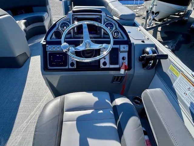 Slide: The Image of 2024 Berkshire 23RFX STS 2.75 boat dashboard with steering wheel and controls. - 11