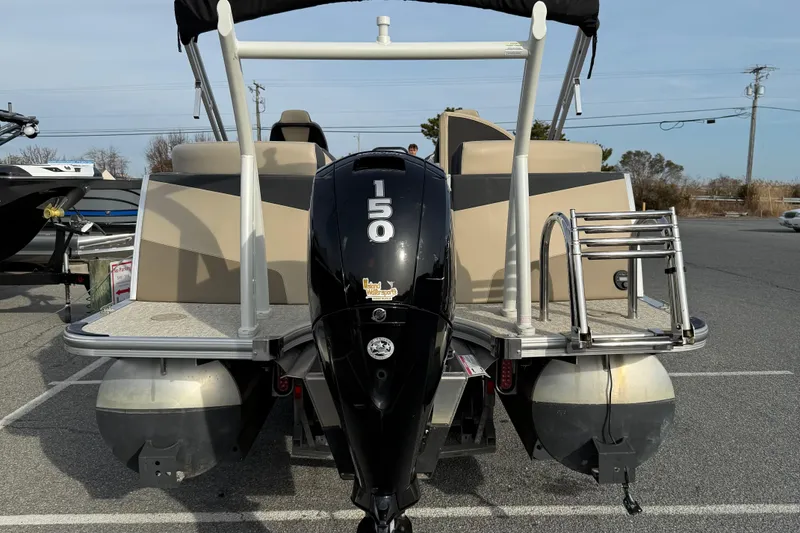 Slide: The Image of 2024 Berkshire 23RFX STS pontoon boat with powerful outboard motor, parked on asphalt. - 16