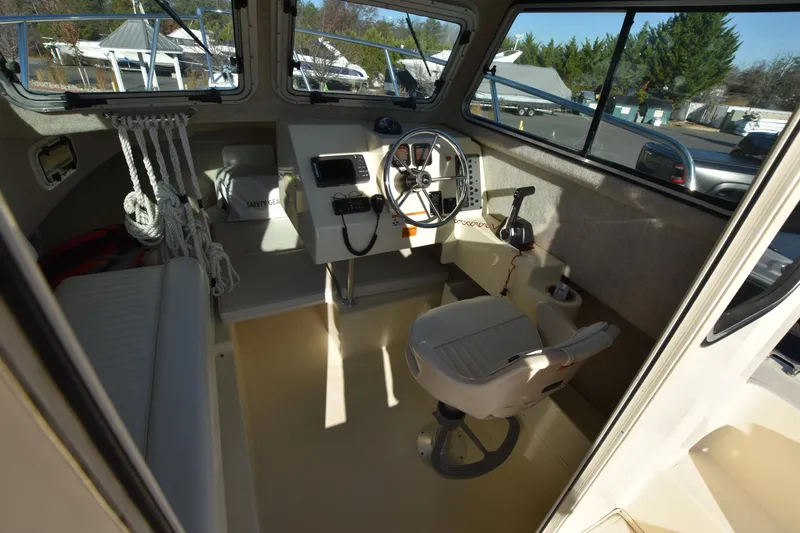 Slide: The Image of Interior of 2013 Parker 2320 SL Sport Cabin boat, featuring helm and seating area. - 17