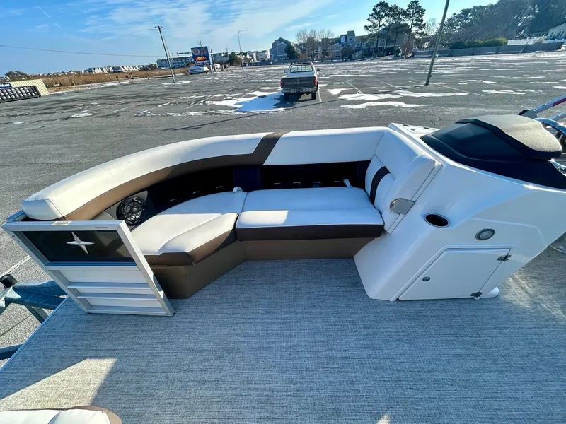 Slide: The Image of 2024 Berkshire 24RFC CTS 2.75 pontoon boat interior with plush seating in a parking lot. - 10